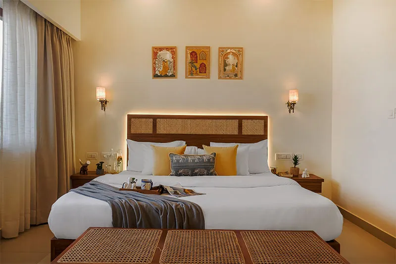 Deluxe Room bed with wall art and reading lamps