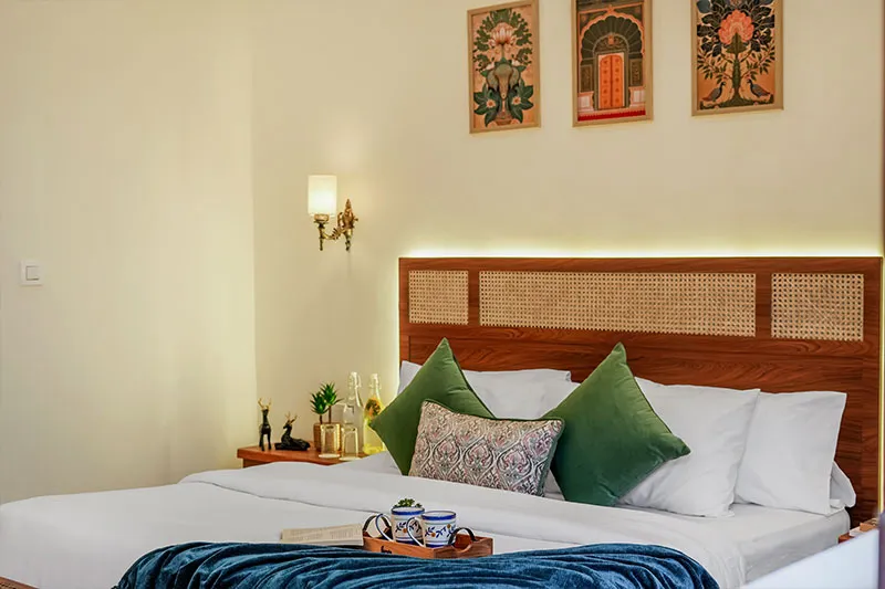 Bedroom with green cushions and wall art at Manovan Resort
