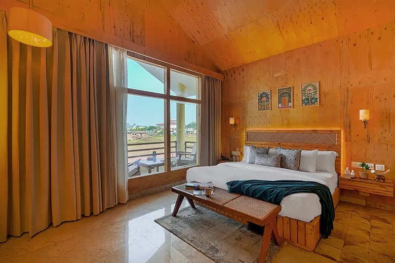 Wood-panelled bedroom with private balcony and forest view at Manovan Resort