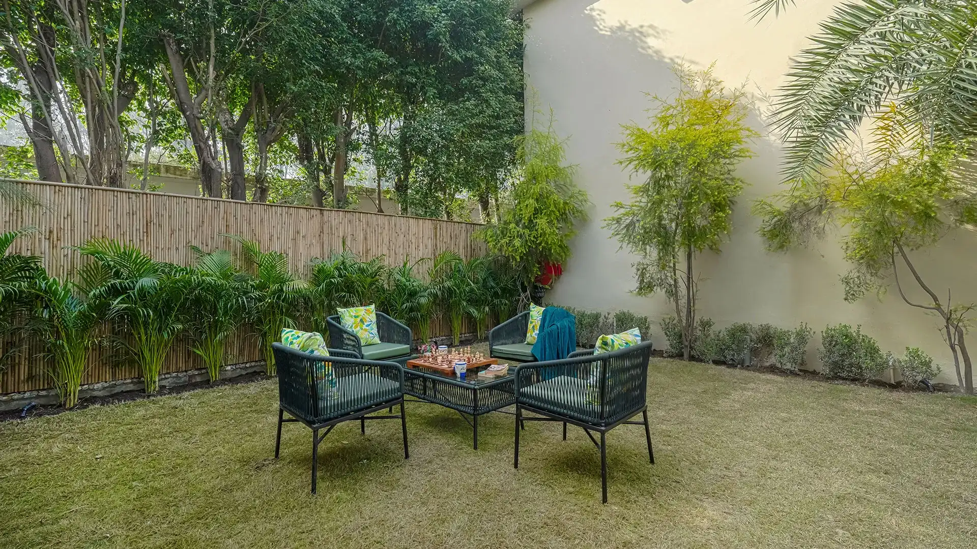 Outdoor lawn seating area surrounded by trees at Manovan Resort